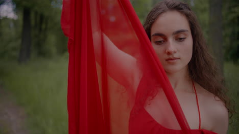 mujer inocente en vestido rojo bosque