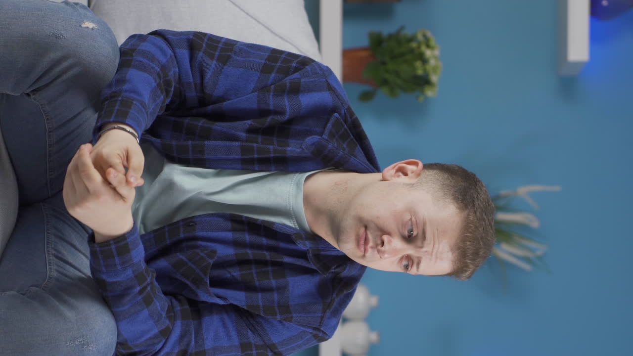 el video vertical del hombre pesimista está confundido en casa.