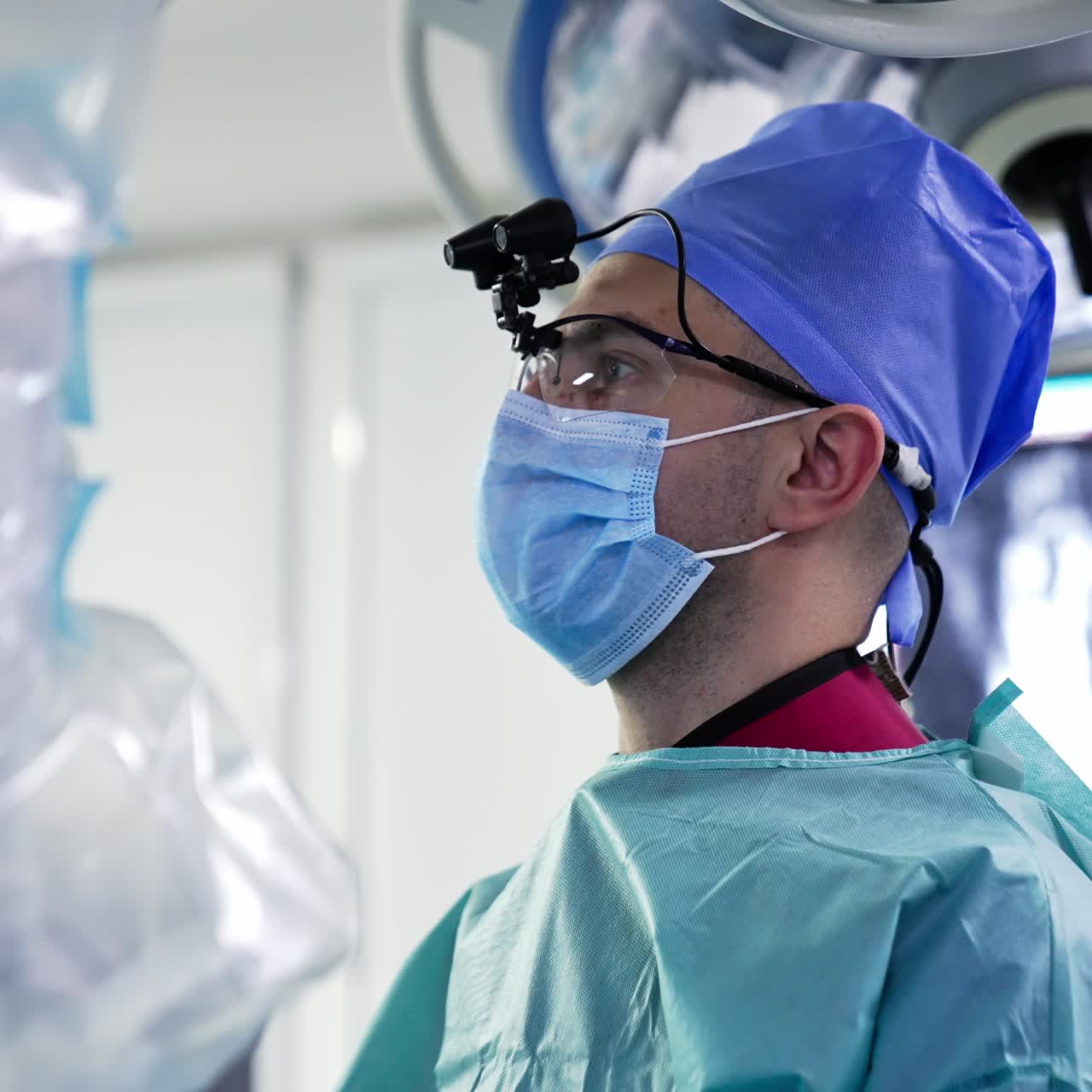 Surgeon professional wearing special glasses with device. Specialist looking intently in front of himself. Side view. Blurred background