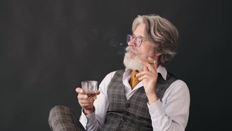 video-of-a-well-dressed-man-smoking-a-cigar-whilst-drinking-whisky-and-enjoying-his-time-after-work