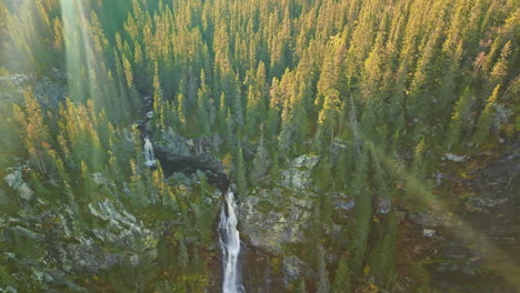 Sunrays-Over-Waterfalls-Amidst-Autumnal-Fir-Forest-During-Sunset-In-Sweden