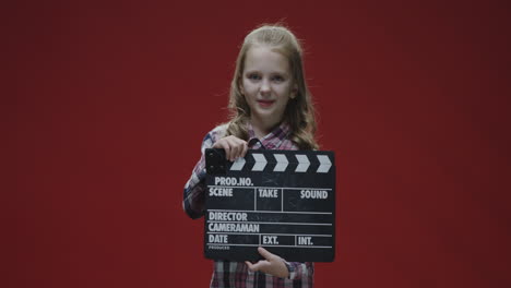 young girl holding a clapperboard