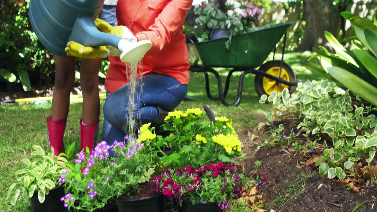 abuela y nieta regando las plantas