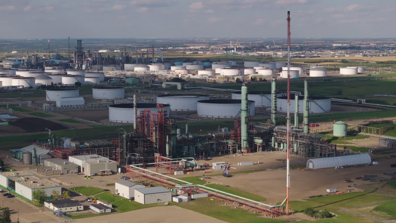 Ampia visuale di un complesso di raffinerie industriali sotto un cielo blu, ambientazione diurna