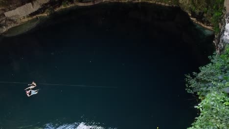 two people swimming in an underground cave cenote