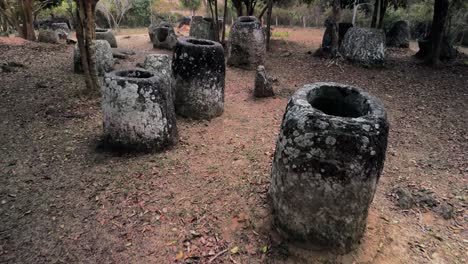 plain of jars, drone fly through jungle closeup to megalithic structures