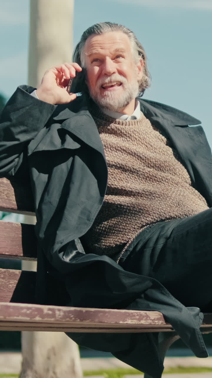 Uomo stiloso che parla al cellulare in un parco