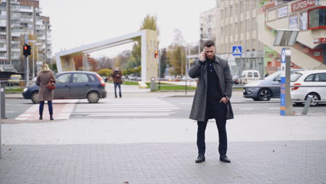 businessman with mobile phone outdoors. young businessman talking on mobile phone on street