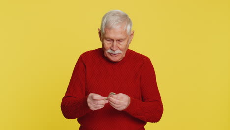 Poor senior old man insufficient amount of money holding piggybank and one dollar banknote crisis