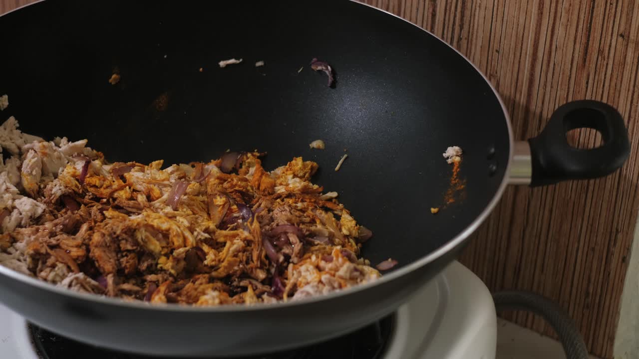 Adding Soy Sauce and Pepper to Shredded Chicken in Wok – Close-Up Shot
