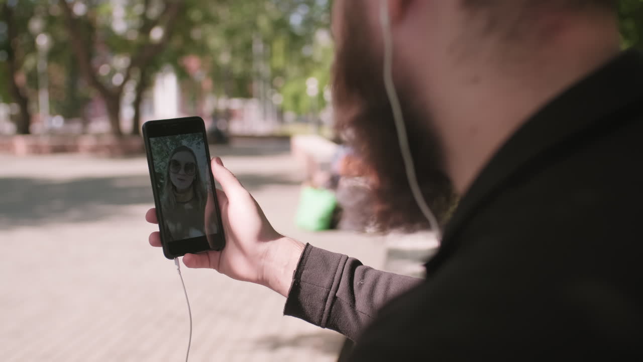 Man Talking on Video Call on Mobile Phone Outdoors