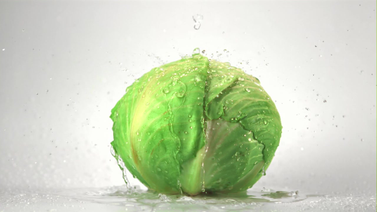 Fresh Green Cabbage Being Washed with Water in Slow Motion