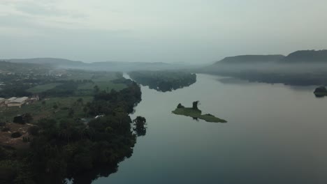 Toma-Aérea-De-Un-Lento-Descenso-Con-Vistas-A-Los-Edificios-Del-Pueblo-Y-La-Isla-En-El-Río-Volta.