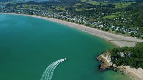 Tour-boat-taking-passengers-to-see-the-blowhole-in-Cooks-beach-on-a-perfect-summers-day