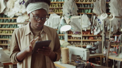 Mujer-Afroamericana-Trabajando-En-Tableta-En-Taller-De-Zapatero