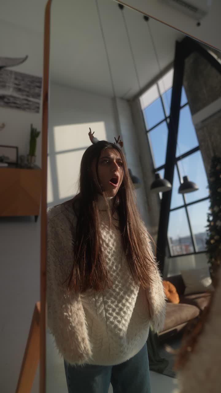 mujer mirándose en un espejo decorado para navidad