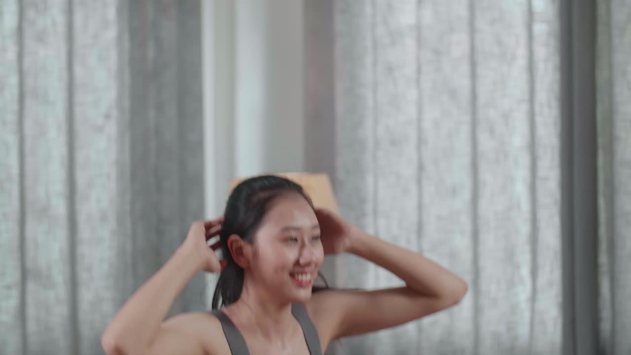 스포츠 옷을 입은 젊은 아시아 운동선수 여성이 집에서 매일 운동하는 동안 심장, 높은 무 및 스 운동을 하는 근접 초상화