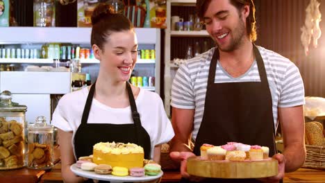 Retrato-De-Camarero-Y-Camarera-Sosteniendo-Una-Bandeja-De-Pastelitos