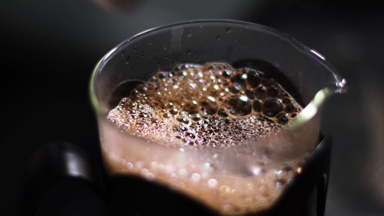 Stirring hot coffee with a small spoon in a French press. Coffee for breafast. Aroma. Close up shot