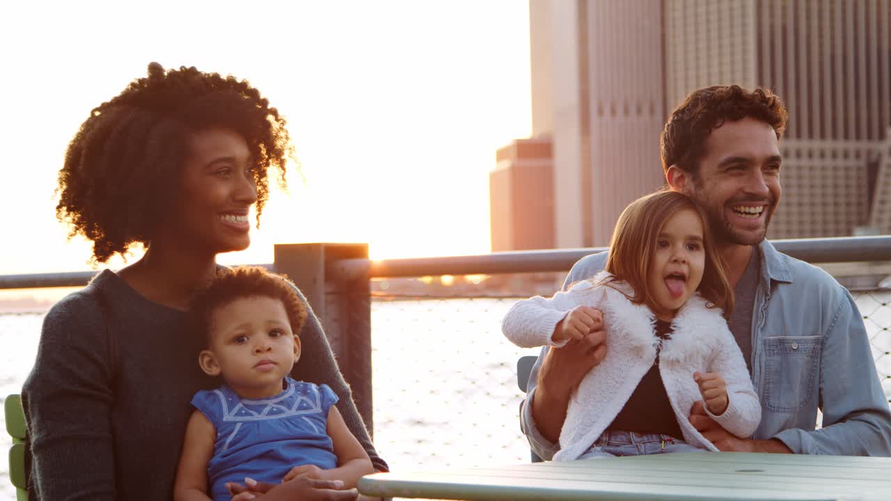 Two families sitting at a table by the river in Manhattan