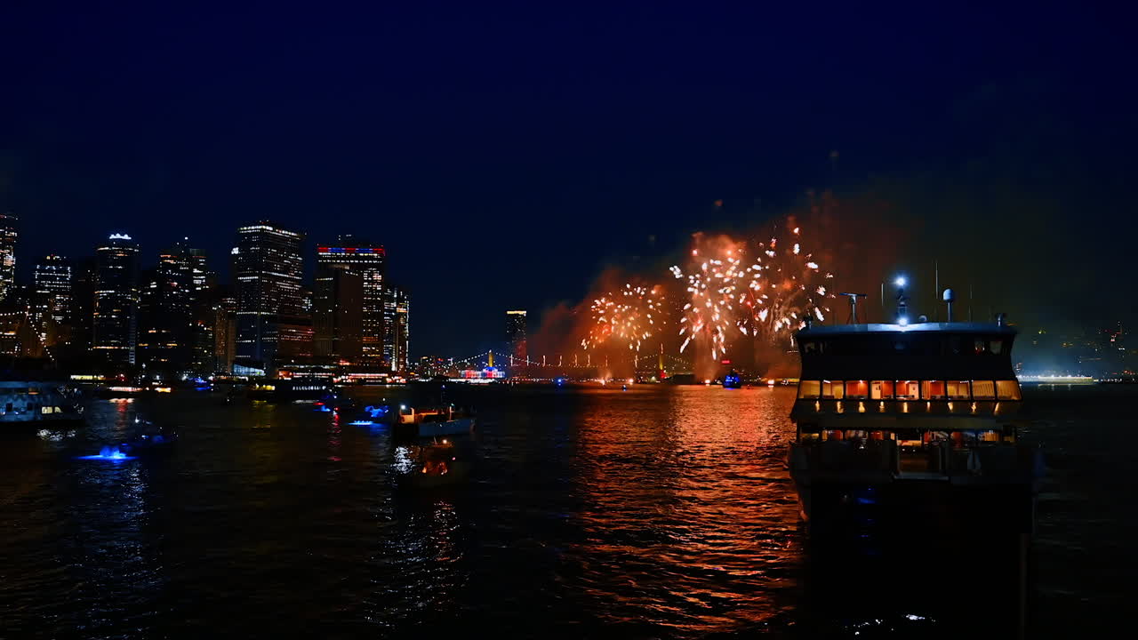 Colorful flashes of fireworks over the East River in New York, USA. Multiple boats gathered at the waterscape to enjoy the 4th July celebration show