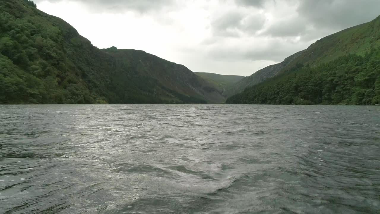무인 항공기 비행 낮은 glendalough 호수 물 표면, 야생 풍경, wicklow 산