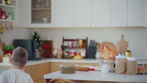 a young boy runs into kitchen to bake gingerbread cookies