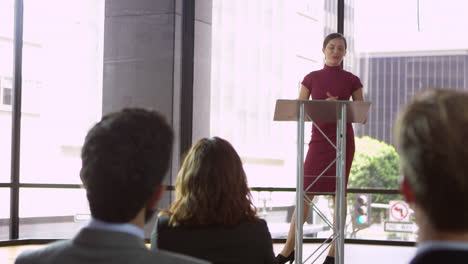 Mujer-Joven-En-Un-Atril-Presentando-Un-Seminario-De-Negocios,-Filmada-En-R3d