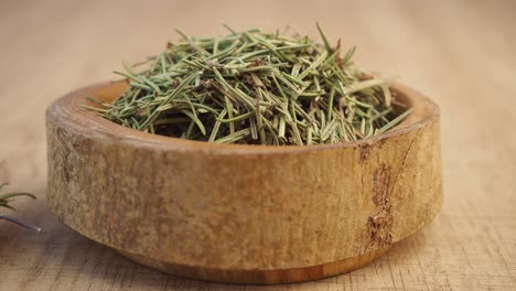 dried rosemary in wooden bowl