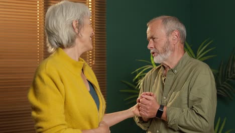 an elderly couple holding hands and conversing