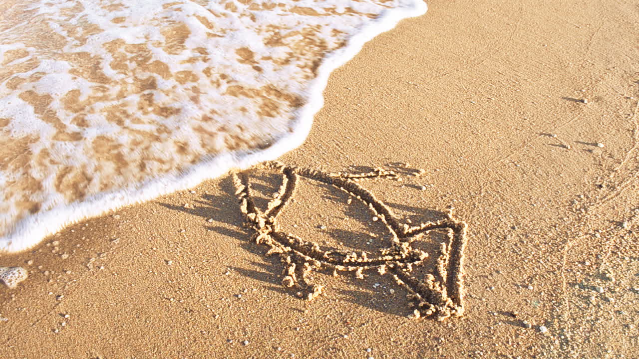 The drawing of fish on sand. Shooting on the beach