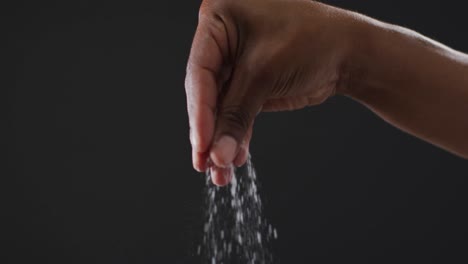 video of cook throwing salt on the table on black background