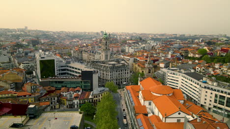 Hermoso-Edificio-Con-Techo-Naranja-Y-Torre-De-Iglesia-Alta-En-Una-Gran-Plaza-Llena-De-árboles-Verdes-En-El-Centro-De-La-Ciudad-Portuguesa-De-Oporto-En-Un-Día-Nublado