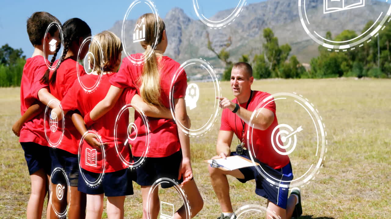 male coach and kids kneeling on field, showing animated sports strategy arrows and stopwatch