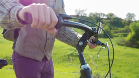 Un-Hombre-Conduce-Una-Bicicleta-A-Través-De-Un-Prado-Verde