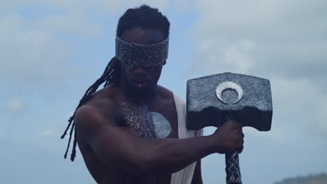 at a tropical beach, a muscular, dark-skinned man expertly brings nekharis to life through cosplay