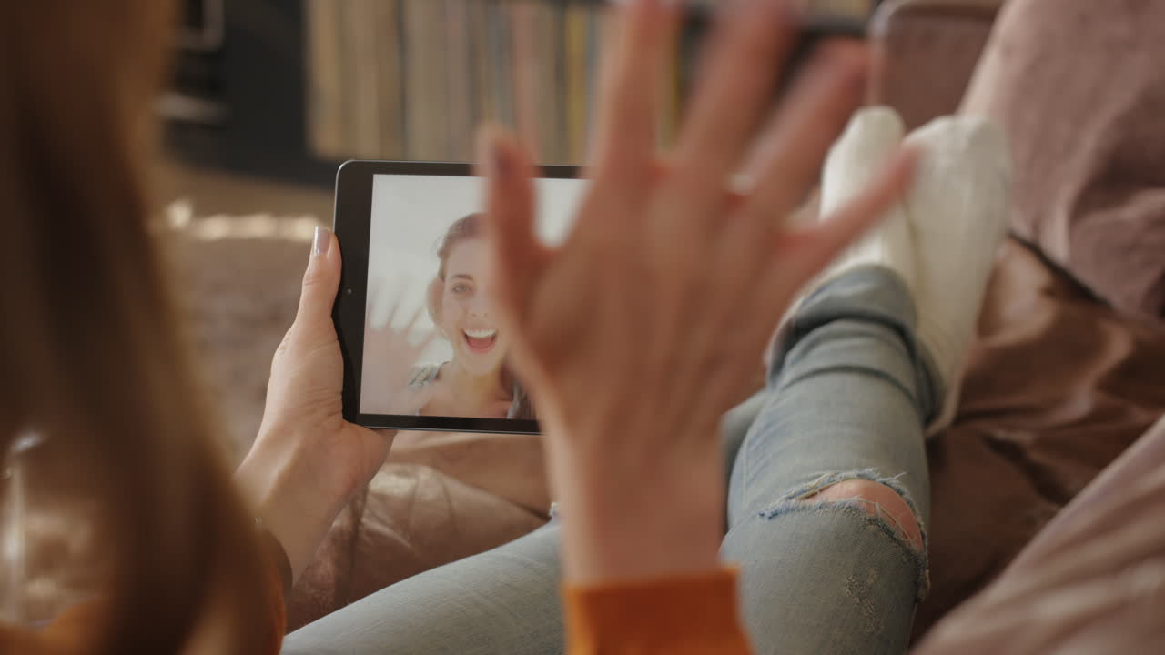 mujer usando una tableta digital sosteniendo un saludo agitando