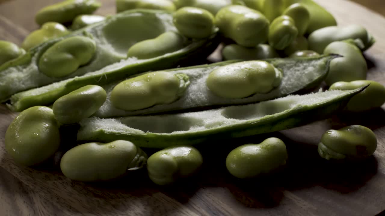 Fresh fava beans on a wooden surface