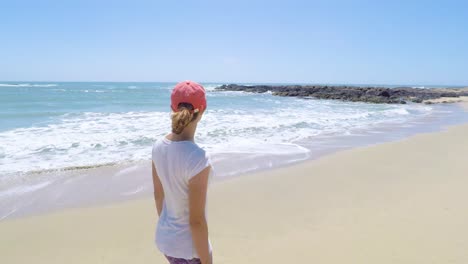 Mujer-Joven-Caminando-En-Una-Playa-En-La-Costa-Oeste,-EE.UU.