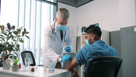 Back-View-Of-Hindu-Young-Male-Patient-Having-Vaccine-In-Clinic