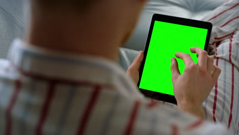 hombre de negocios deslizando la tableta de maqueta en casa de cerca. dispositivo de plantilla de pantalla verde