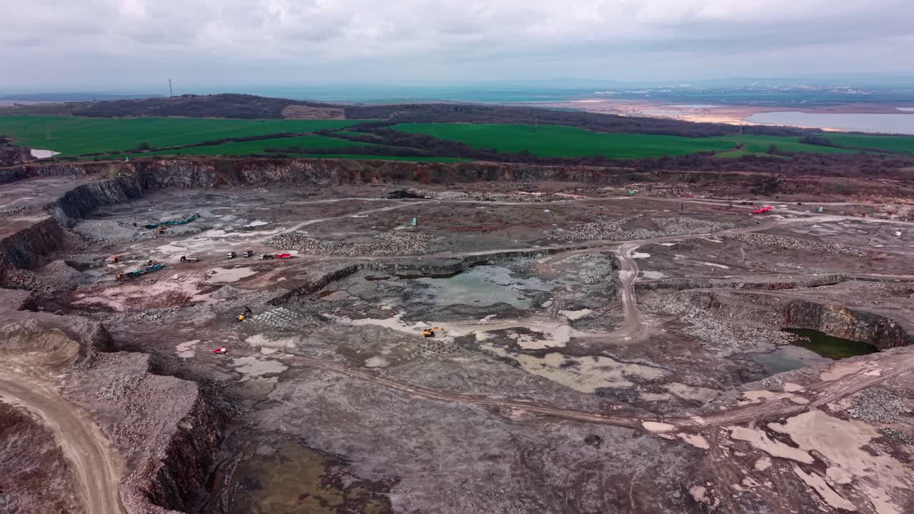 Sito di cava di granito che mostra lavori di estrazione in corso in un'area a cielo aperto.