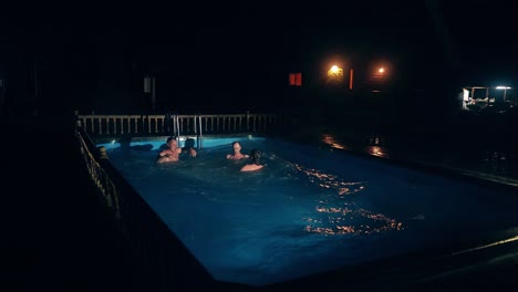 Young-Russian-guys-at-night-during-the-rest-after-bath-synchronously-dive-into-the-pool
