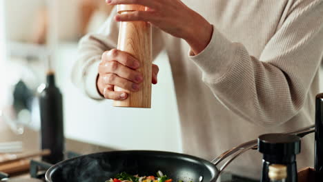 person seasoning vegetables in a pan