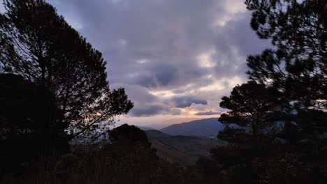 Schwere-Und-Dramatische-Sturmwolken-Ziehen-Im-Zeitraffer-Durch-Waldhänge