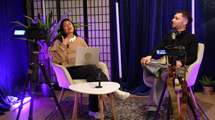 Kvinde og mand optager et podcastinterview i et moderne studie