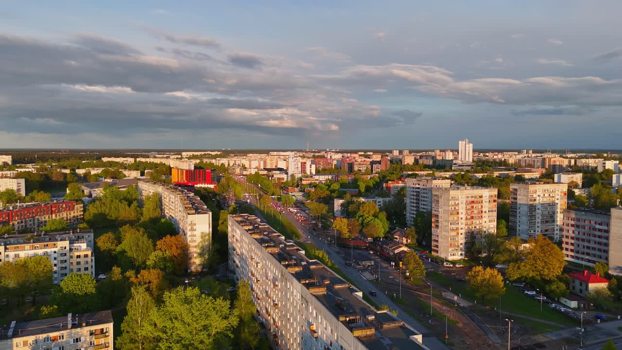 Latvian cityscape bathed in golden sunset light, casting warm tones on blocks and streets.
