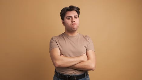 sad and angry man standing with arms crossed looking around