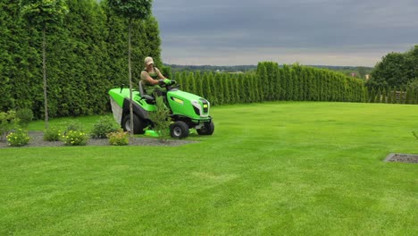 hombre cortando el césped en un tractor de césped.