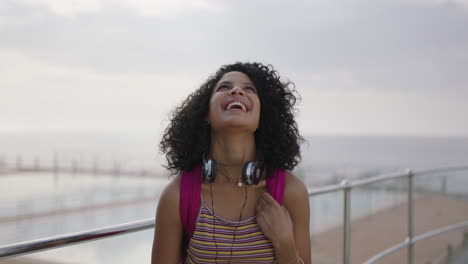 portrait-of-beautiful-mixed-race-woman-by-seaside-swimming-pool-laughing-cheerful-outdoors